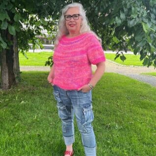 Produktbilde av en modell i den strikkede toppen Vitamin som selges som en strikkepakke og er designet i Bella og Bella Color by Permin. I tillegg til Jawoll fra Langyarns. Her i fargen Pink.