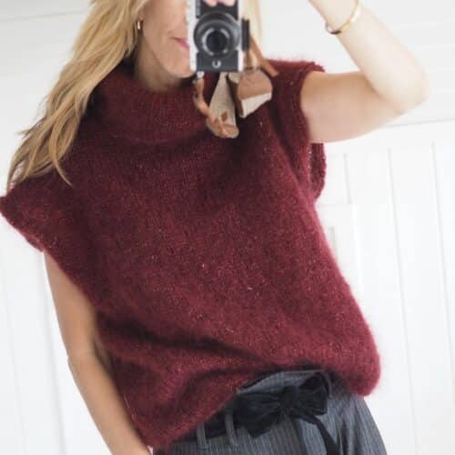 Produktbilde: Modell i front selfie i speil. Strikkepakke Bea vest designet av Tove Lindtein, strikket i Bellissima fra by Permin.