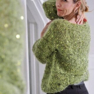 Produktbilde: Modell baksiden. Strikkepakke Holiday sweater designet av Tove Lindtein, strikket i Bella by Permin og Cosmo fra Lana Grossa.