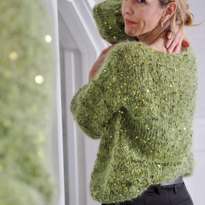 Produktbilde: Modell baksiden. Strikkepakke Holiday sweater designet av Tove Lindtein, strikket i Bella by Permin og Cosmo fra Lana Grossa.