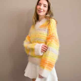 Produktbilde: Modell på skrå i front. Strikkepakke Fuzzy mista v-neck designet av Tove Lindtein, strikket i Basta og Basta Mista fra Lana Grossa.