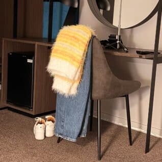 Produktbilde: Genser Fuzzy mista v-neck genser henger over en stol. Designet av Tove Lindtein, strikket i Basta og Basta Mista fra Lana Grossa.