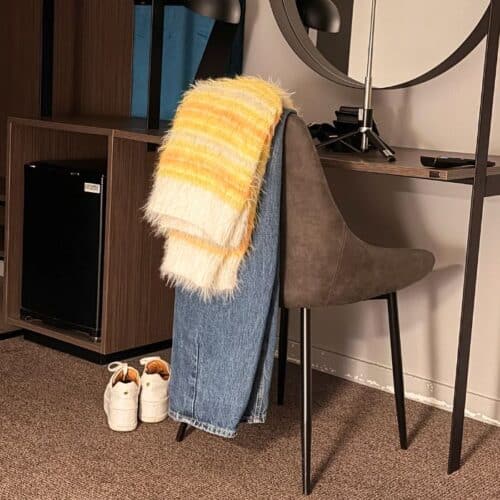 Produktbilde: Genser Fuzzy mista v-neck genser henger over en stol. Designet av Tove Lindtein, strikket i Basta og Basta Mista fra Lana Grossa.